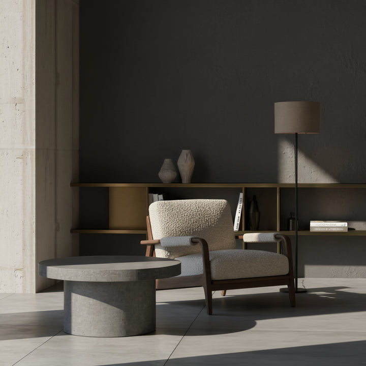 Runder, grauer Couchtisch 60 cm Durchmesser in Beton-Optik mit zylindrischem Sockel im Zentrum einer Raw & Refined-Einrichtung_