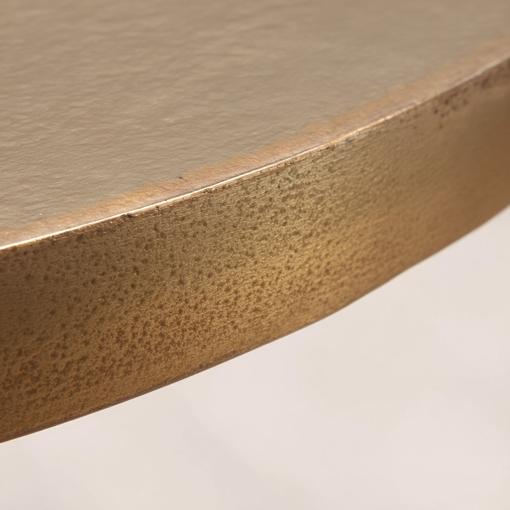 Aluminiumtisch in Gold mit edler Oberfläche, kombiniert mit hellen Möbeln