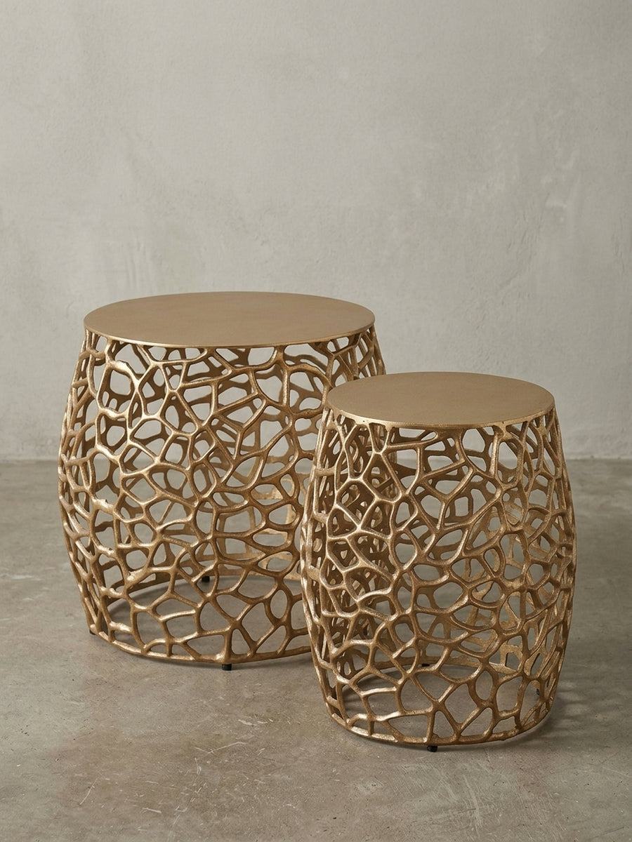 Schrägansicht des zweiteiligen Sofatisch-Sets aus goldenem Metall, das die bauchige Form und die massive Tischplatte hervorhebt._