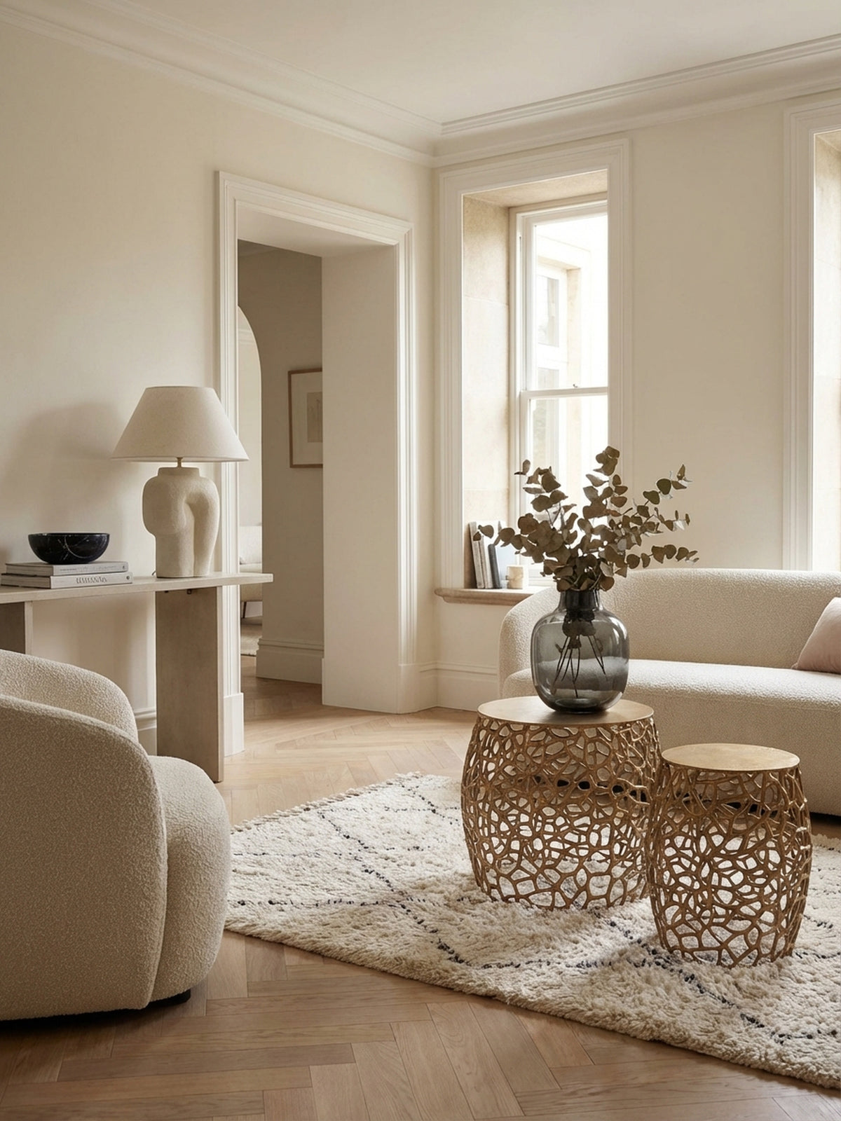 Das goldene Beistelltisch 2er Set aus Aluminium als eleganter Blickfang im Wohnzimmer neben einem modernen Sofa auf einem hellen Teppich._