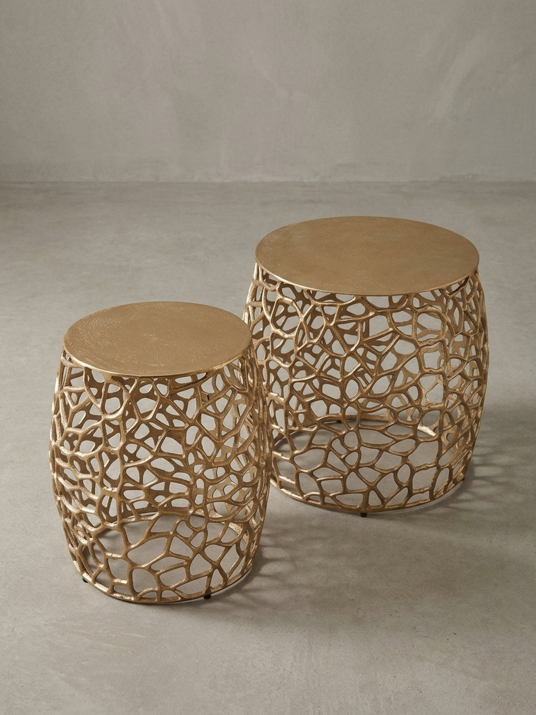 Das zweiteilige Couchtisch-Set aus Aluminium, bei dem der kleinere Tisch teilweise unter den größeren geschoben ist, um die Nesting-Funktion zu demonstrieren._