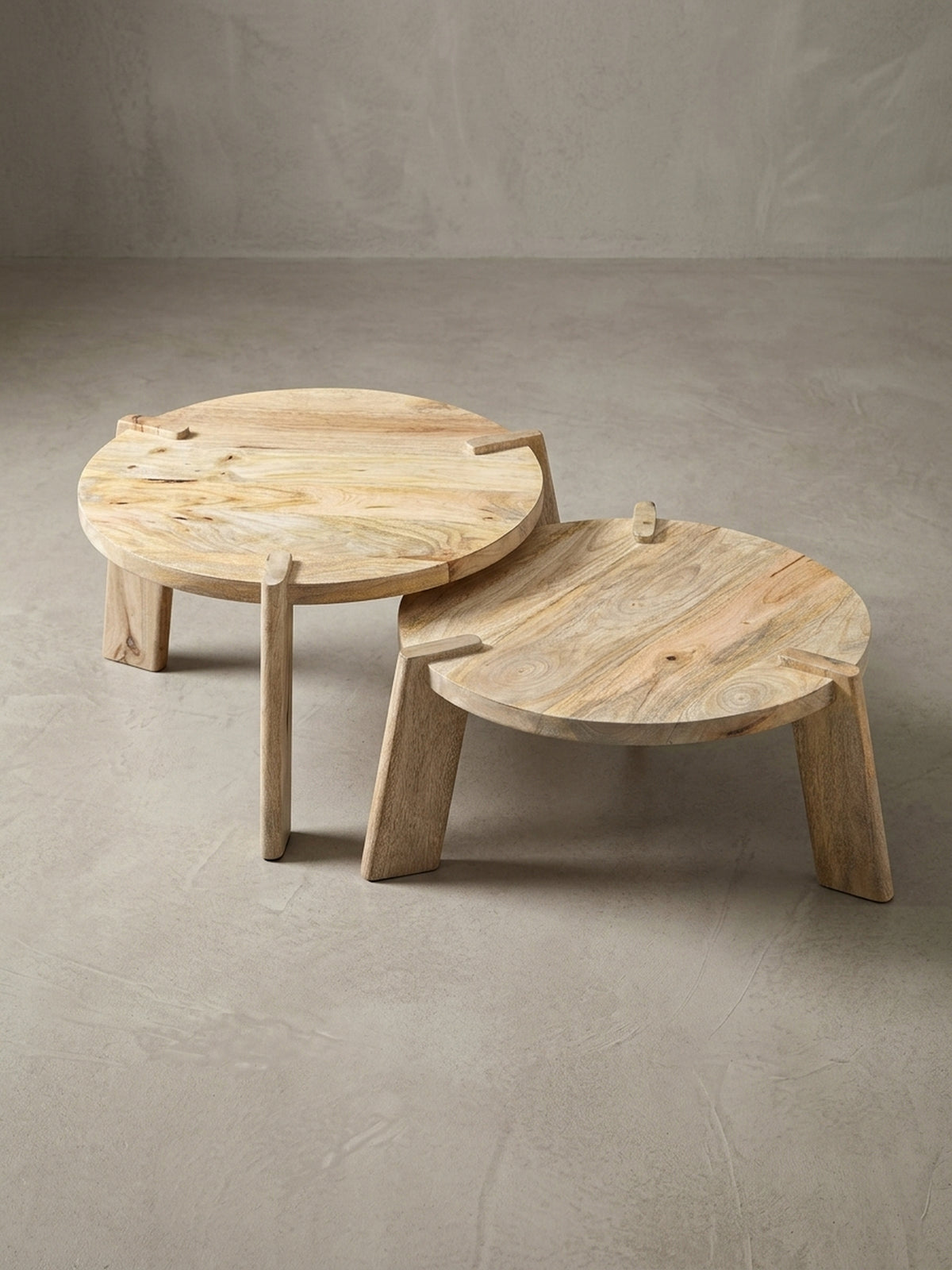 Nahaufnahme der durchgesteckten Tischbeine des runden Satztisches, ein charakteristisches Designmerkmal des Mango-Holztisches.