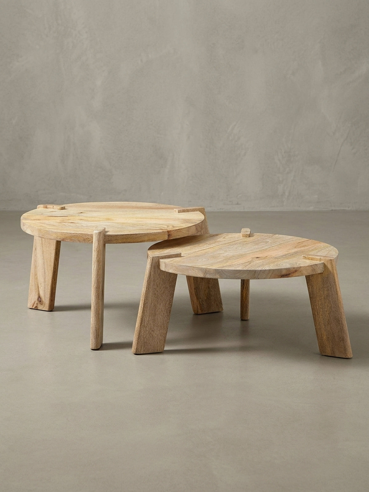 Runder Satztisch aus hellem Massivholz in der 3/4-Ansicht, die das ineinandergreifende Design und die stabilen Holzbeine hervorhebt.