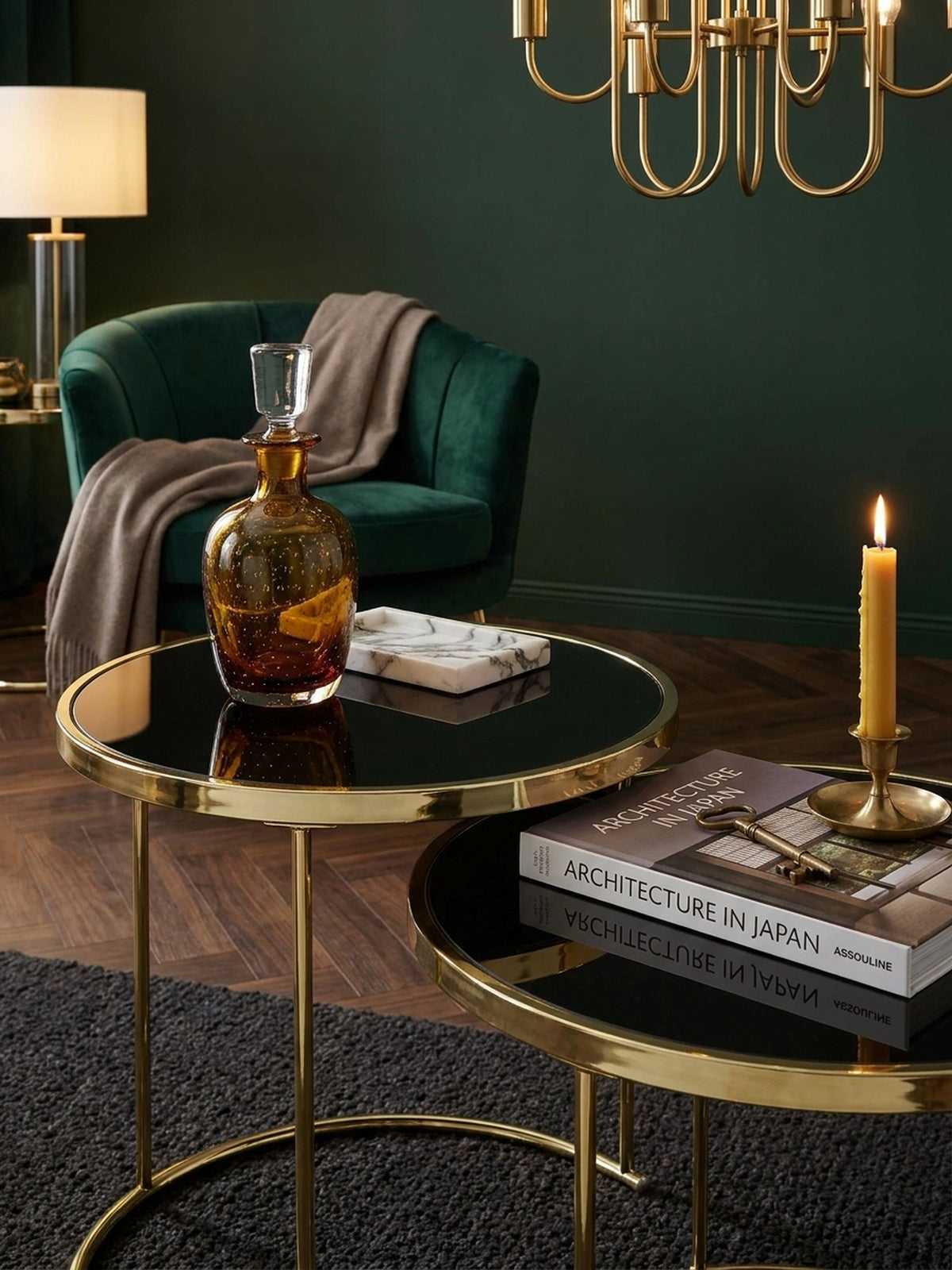 Kleiner Wohnzimmertisch aus Glas und Metall stilvoll dekoriert mit einer Teetasse und Notizbuch unter einer messingfarbenen Stehlampe