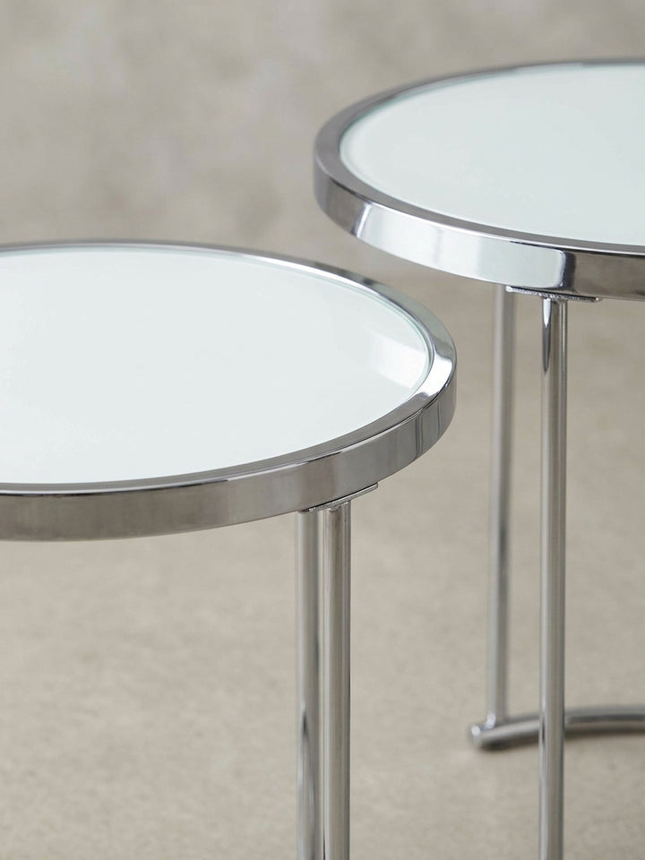 Nahaufnahme eines Details des verchromten Metallgestells des Beistelltisches, das die präzisen Verbindungen und die glänzende Oberfläche des modernen Designs hervorhebt._