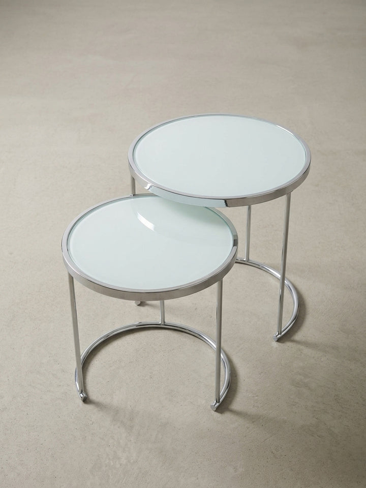 Flexibler Satztisch im 2er Set mit runder, weißer Glasplatte und glänzendem Chromgestell, ideal als kleiner, moderner Wohnzimmertisch oder Nachttisch._
