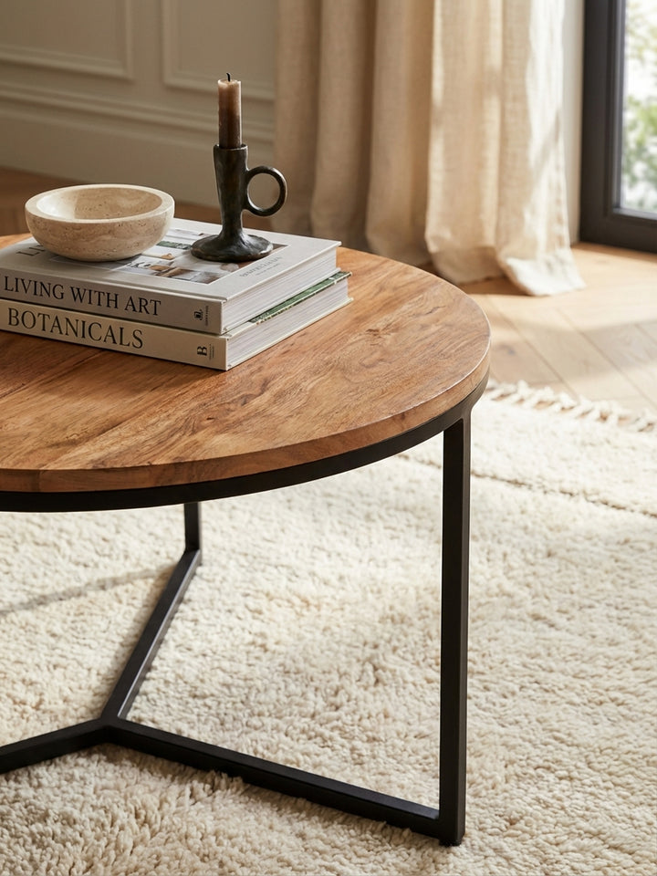 Detailaufnahme der Massivholz Tischplatte aus Akazie mit sichtbarer Holzmaserung und dem mattschwarzen Metallrand des kleinen Couchtisches._
