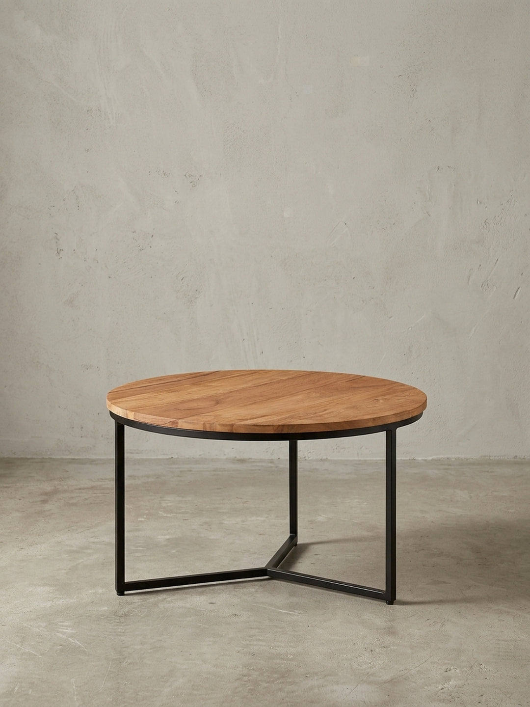 Freigestellter Couchtisch rund 60 cm, Frontansicht des Sofatisches mit warmer Akazienholzplatte und minimalistischem Gestell aus schwarzem Metall._