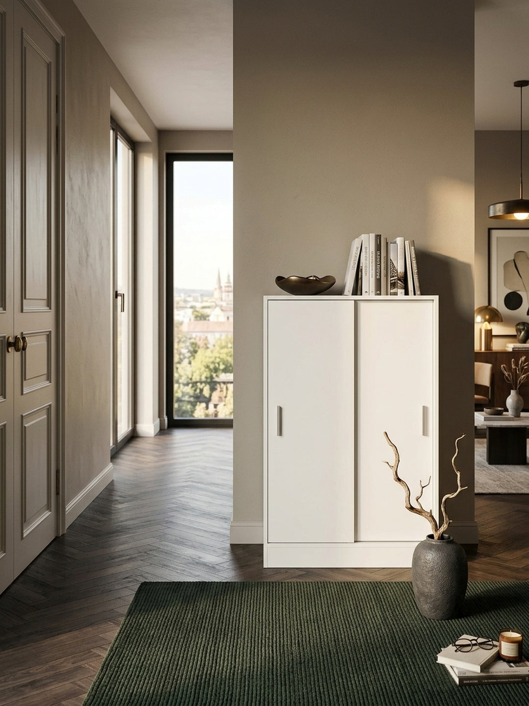 Draufsicht auf den platzsparenden weißen Flurschrank. Die geringe Tiefe von 29cm des Kommodenschranks zeigt sich perfekt an der Wand, dekoriert mit einer Bronzeschale._