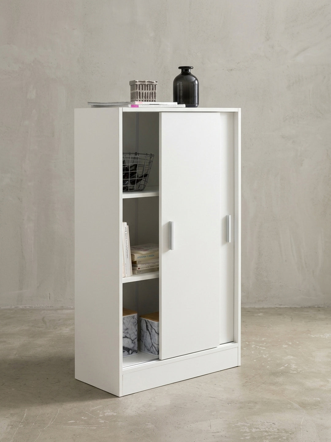 Leicht geöffnete Schiebetür des weißen Aktenschranks offenbart das innere Türfach von 29,5x31x24cm. Der Mehrzweckschrank bietet auf 108cm Höhe viel unsichtbaren Stauraum._