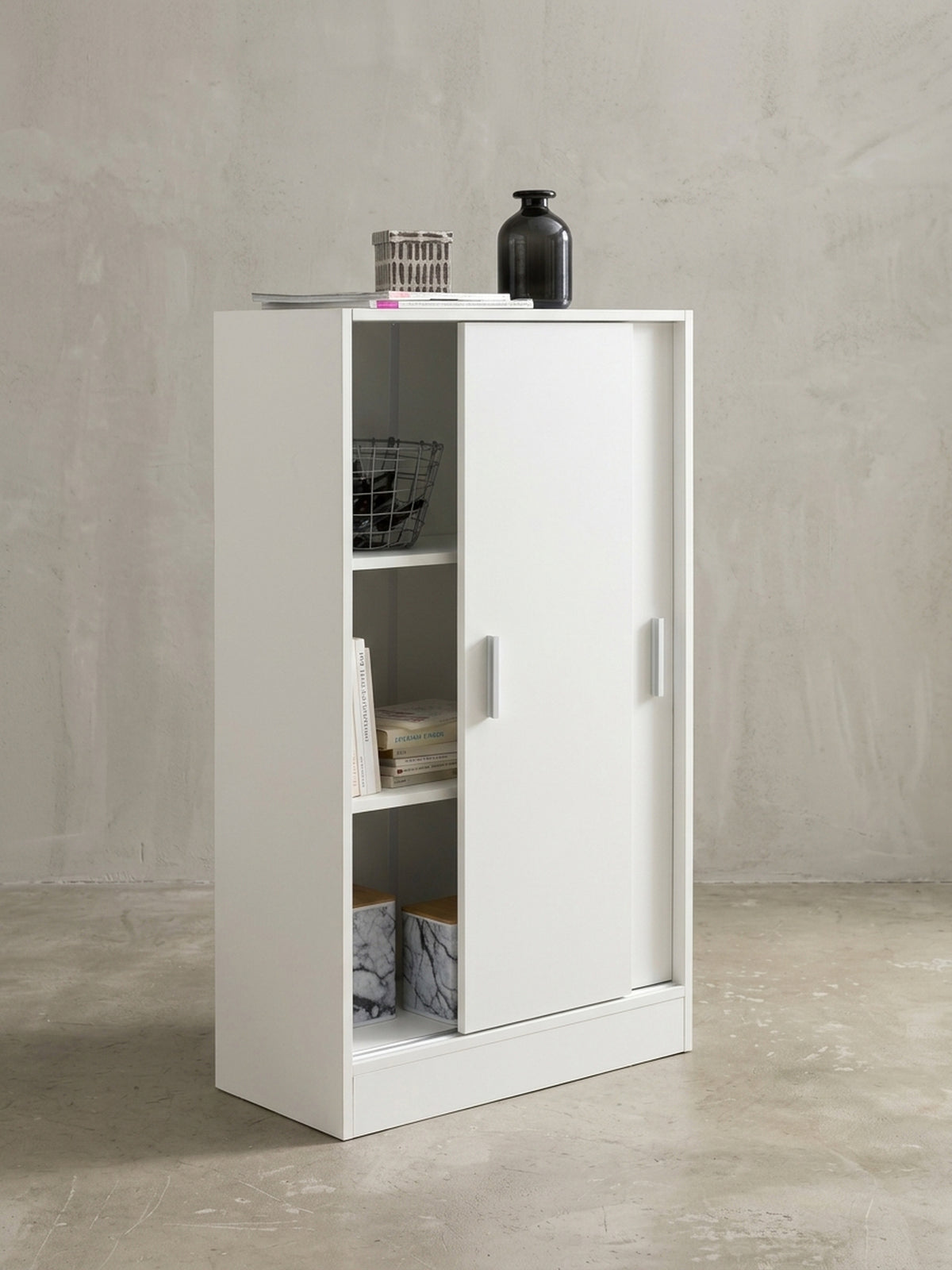 Leicht geöffnete Schiebetür des weißen Aktenschranks offenbart das innere Türfach von 29,5x31x24cm. Der Mehrzweckschrank bietet auf 108cm Höhe viel unsichtbaren Stauraum._
