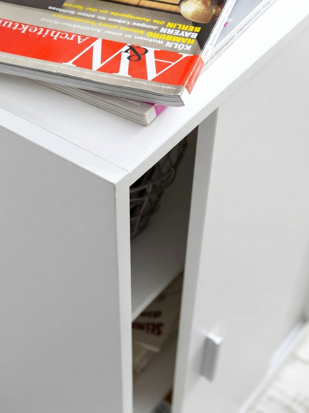 Gesamteindruck des 60x107,5x28,5cm großen weißen Kommodenschranks. Die klare Linienführung und die robusten melaminbeschichteten Oberflächen machen ihn zum Allzweckschrank._