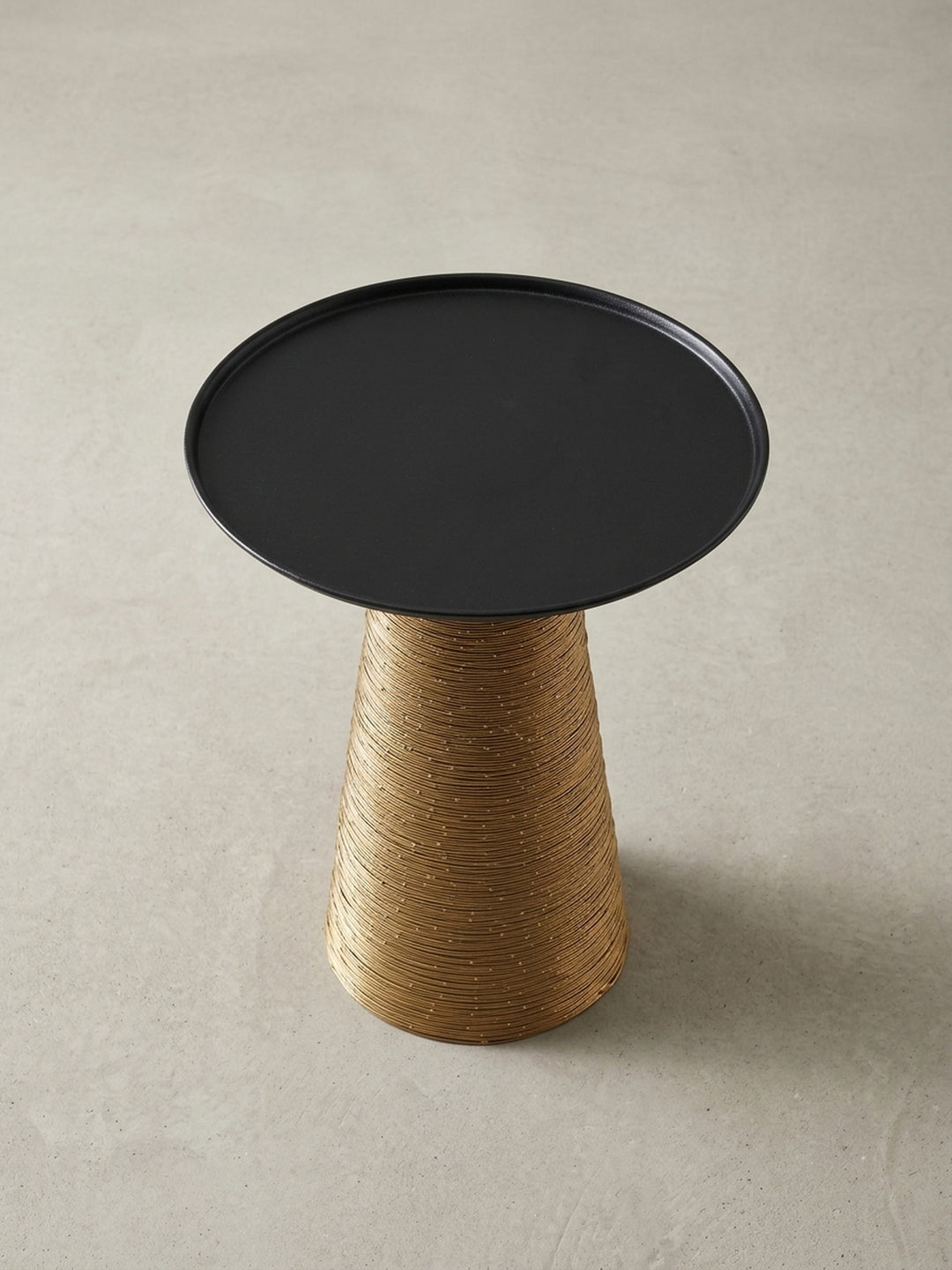 Nahaufnahme der Verbindung zwischen der schwarzen Tischplatte und dem goldenen Standfuß, die die saubere Verarbeitung und das zweifarbige Design des Metall-Couchtisches betont._