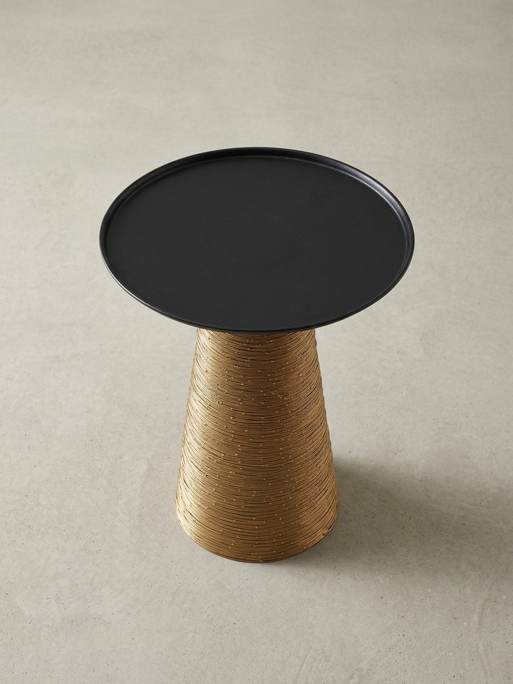 Nahaufnahme der Verbindung zwischen der schwarzen Tischplatte und dem goldenen Standfuß, die die saubere Verarbeitung und das zweifarbige Design des Metall-Couchtisches betont._