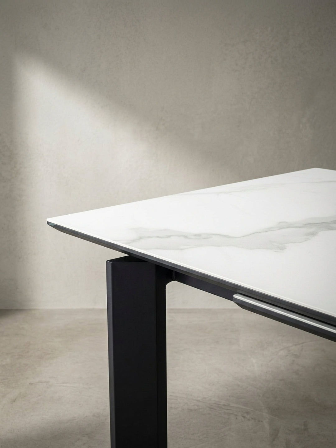 Der große Glastisch mit Keramikoberfläche in einer alternativen Perspektive, die die Reflexionen auf der edlen Marmor-Optik einfängt._