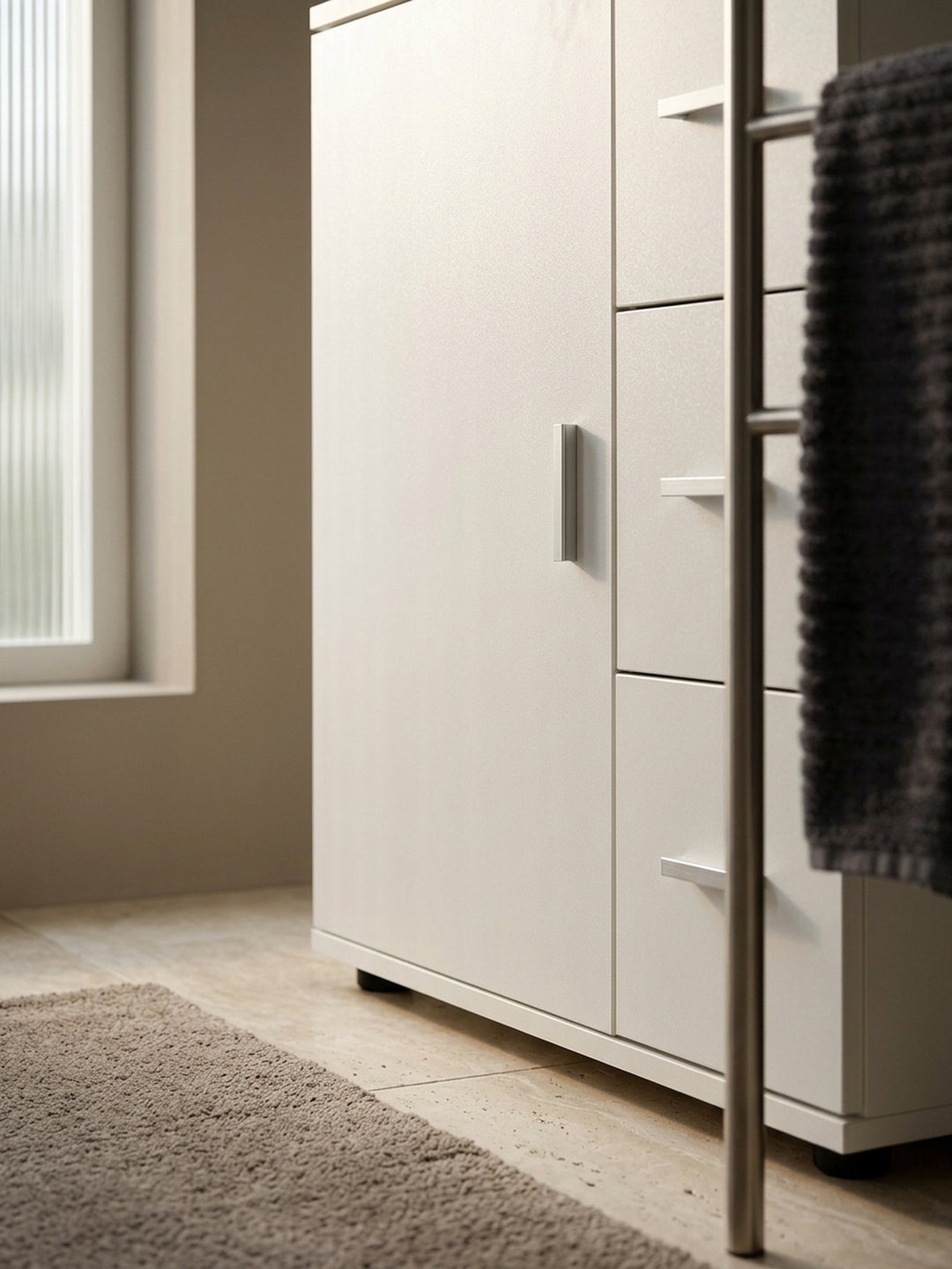 Nahaufnahme der pflegeleichten, melaminharzbeschichteten Oberfläche dieses modernen weißen Badschranks. Die glatte matte Struktur harmoniert perfekt mit den Aluminiumgriffen._