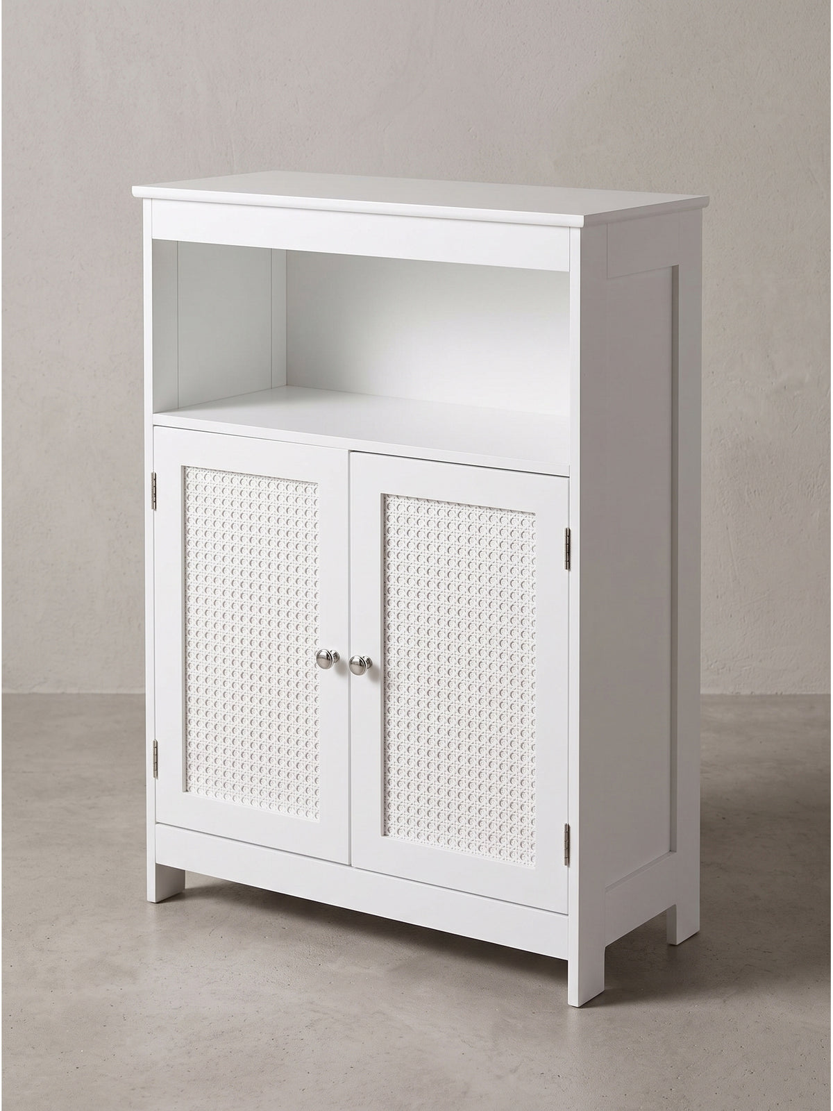 Makroaufnahme der perfekten Kantenverarbeitung des weißen MDF-Holzes und der fein geflochtenen Rattan-Einsätze am eleganten Badezimmerschrank._