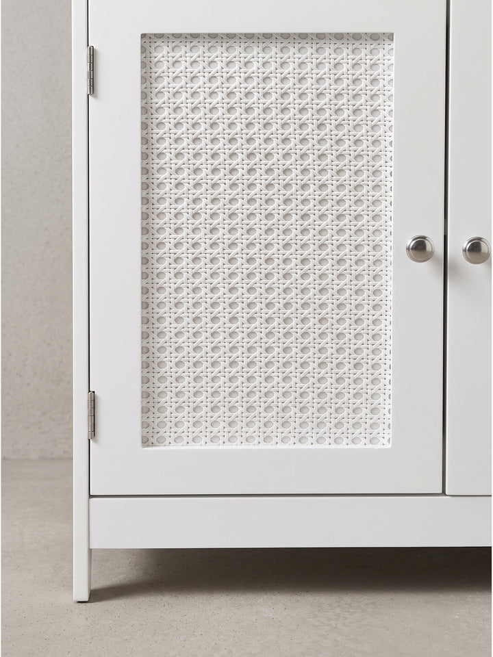 Moderner Badschrank im Boho-Stil mit geradliniger Formensprache, schneeweißem Korpus und dekorativen organischen Türfronten aus echtem Wiener Geflecht._