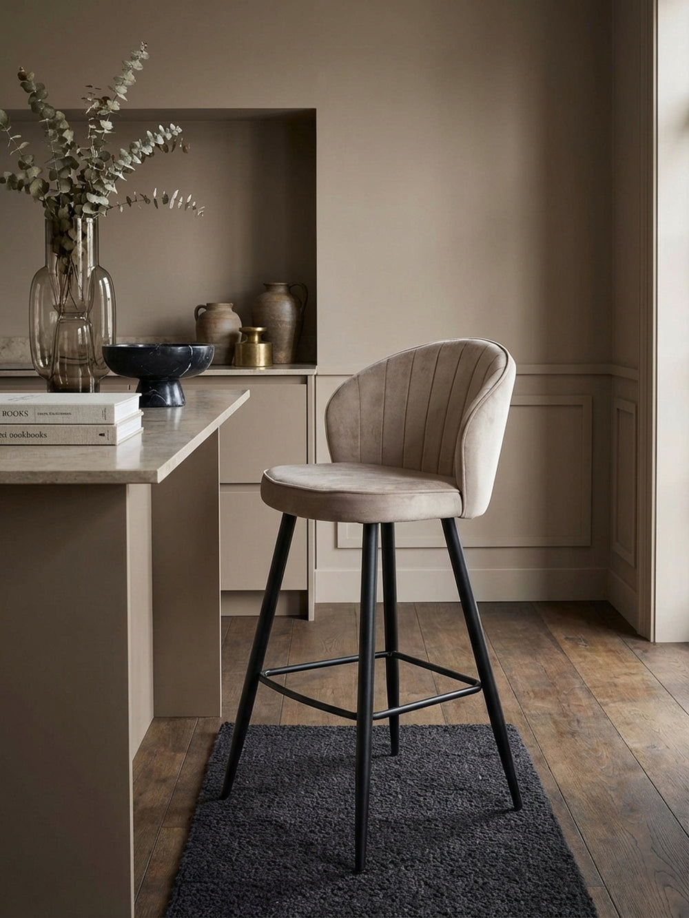 Makroaufnahme des weichen, beigen Samtstoffes des Barhockers, die feine Webart und die luxuriöse Haptik des Polsters hervorhebend._