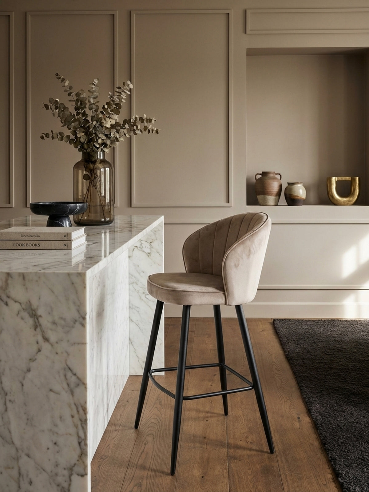 Eleganter Barhocker aus beigem Samt an einer luxuriösen Kücheninsel aus Marmor, passend für ein modernes und klassisches Küchendesign.