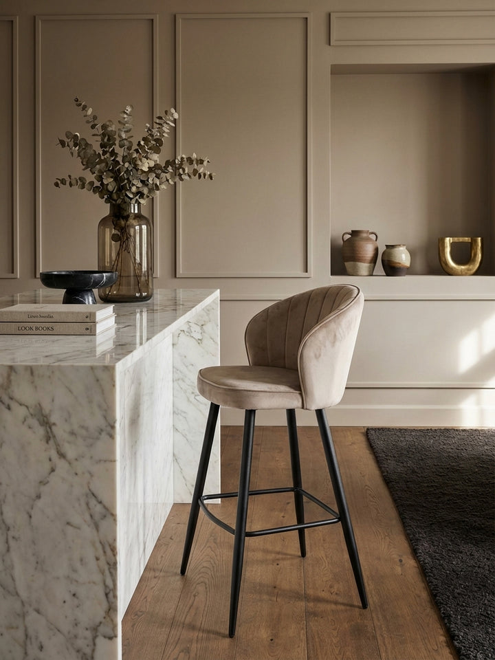 Eleganter Barhocker aus beigem Samt an einer luxuriösen Kücheninsel aus Marmor, passend für ein modernes und klassisches Küchendesign._