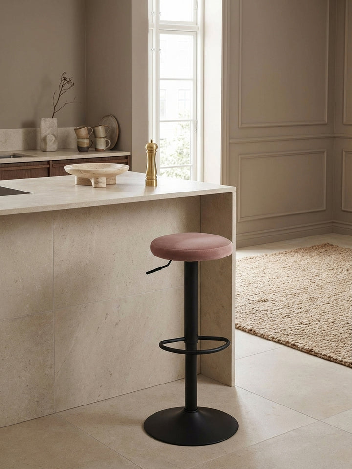 Erhöhte Ansicht des drehbaren Küchenhockers in Rosa Samt am Küchentresen, zeigt die harmonische Integration in ein minimalistisches Interieur._