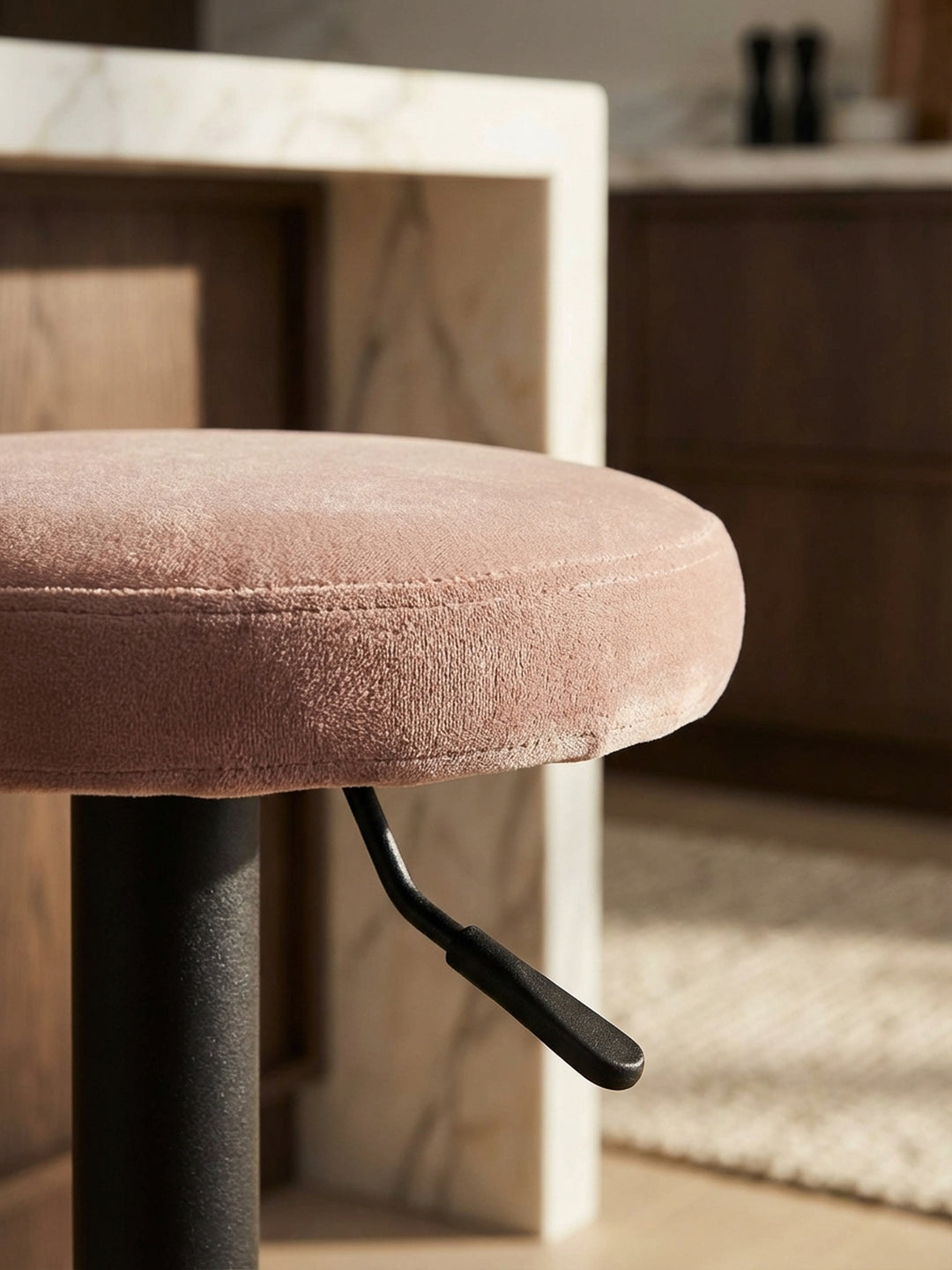 Detailaufnahme der weichen Samtstruktur des rosa Barhockers, die hochwertige Haptik und die feine Verarbeitung des Stoffes betonend._