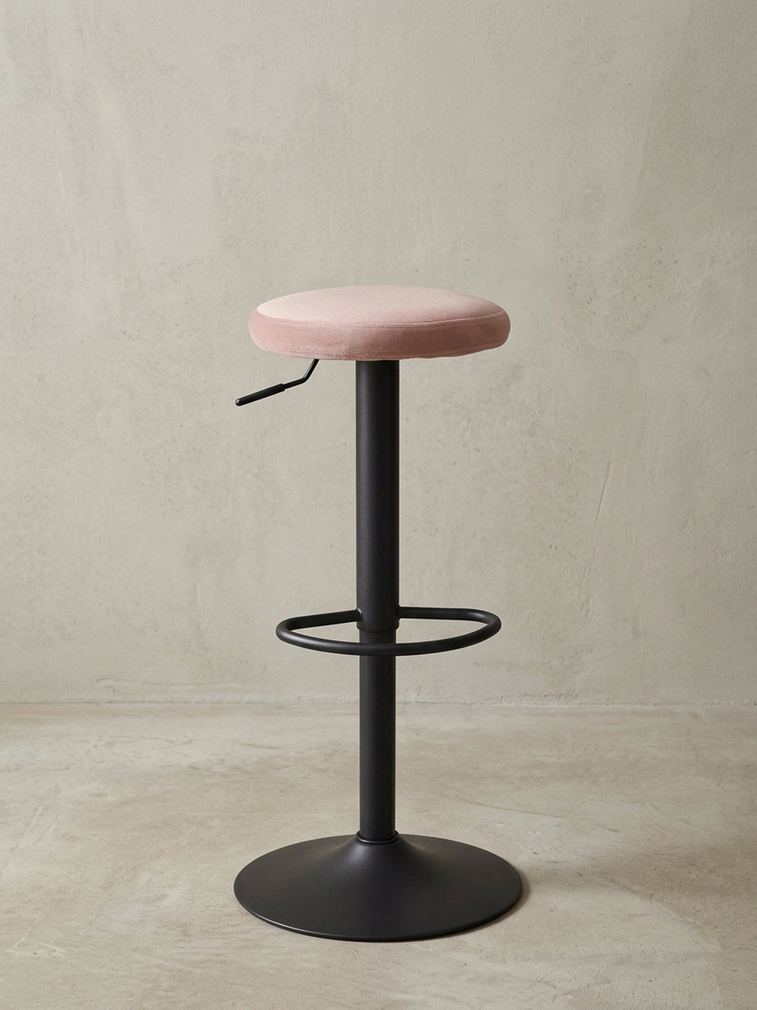 Nahaufnahme des minimalistischen Designs des Barhockers, Fokus auf den Übergang vom schwarzen Standbein zum weichen Samtsitz._