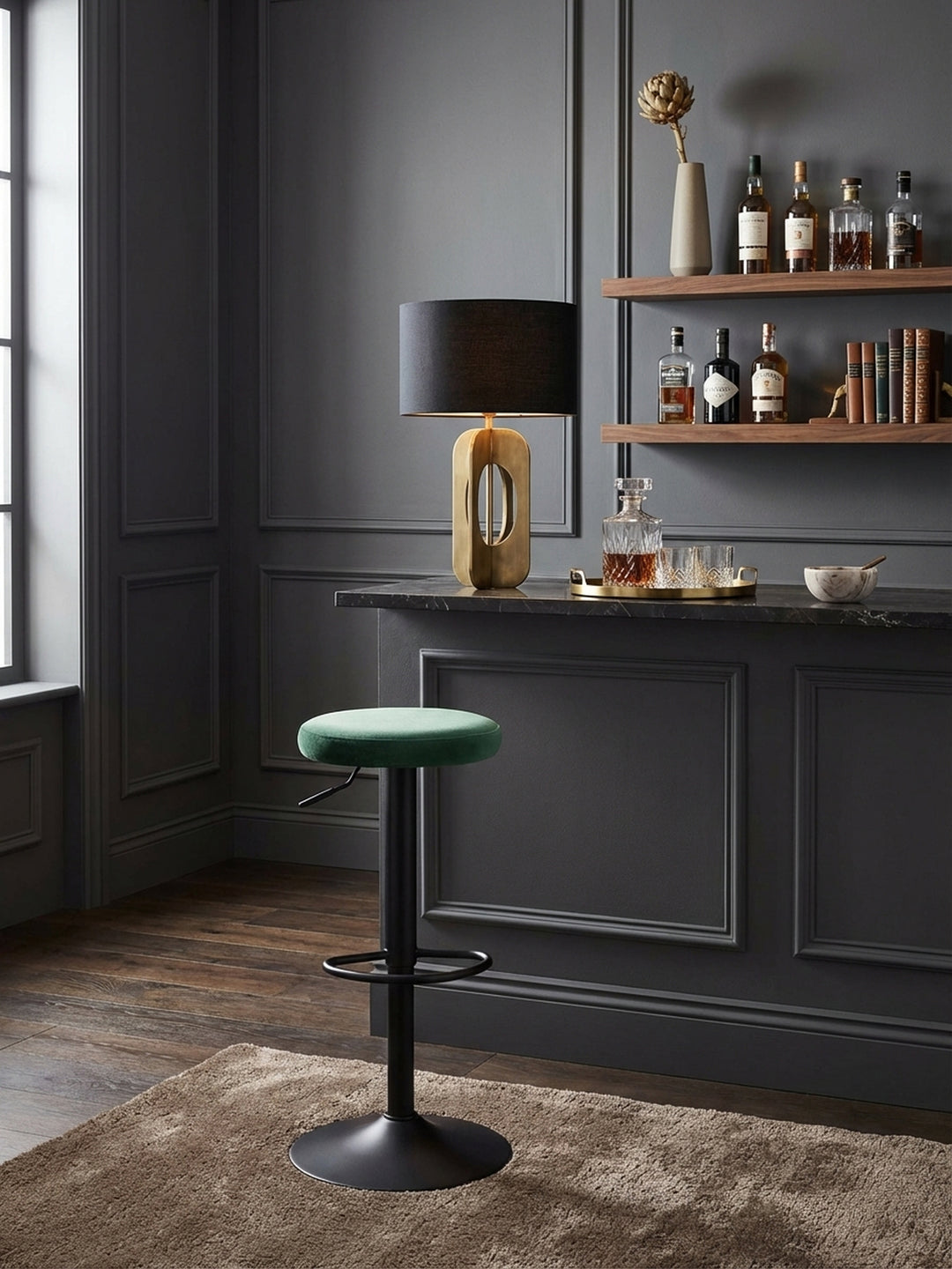 Der drehbare Barhocker in Samt Grün steht elegant an einer dunklen Marmor-Kücheninsel und fügt sich perfekt in ein modernes, luxuriöses Wohnambiente ein._