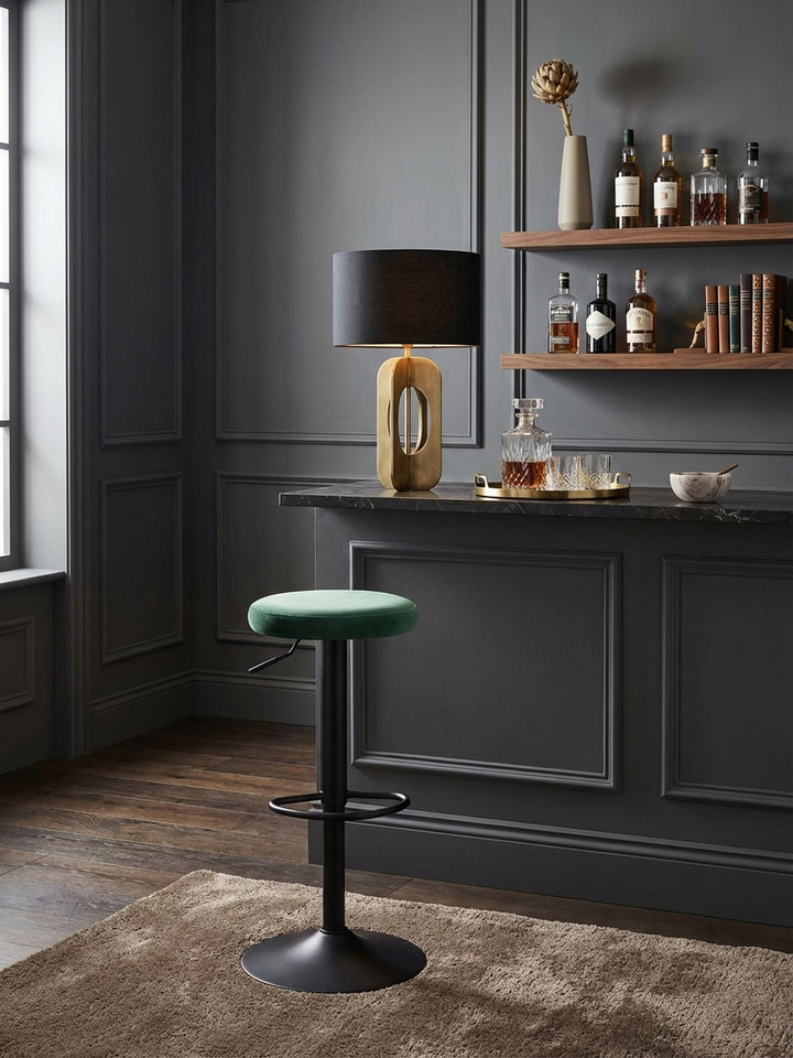 Der drehbare Barhocker in Samt Grün steht elegant an einer dunklen Marmor-Kücheninsel und fügt sich perfekt in ein modernes, luxuriöses Wohnambiente ein._