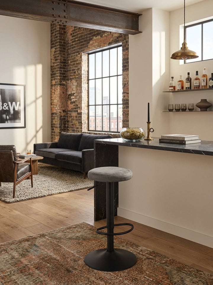 Moderner Barhocker in Grau und Schwarz in einer stylishen Home-Bar mit Holzboden, platziert vor einem hohen Bartisch am Fenster für ein entspanntes Ambiente._