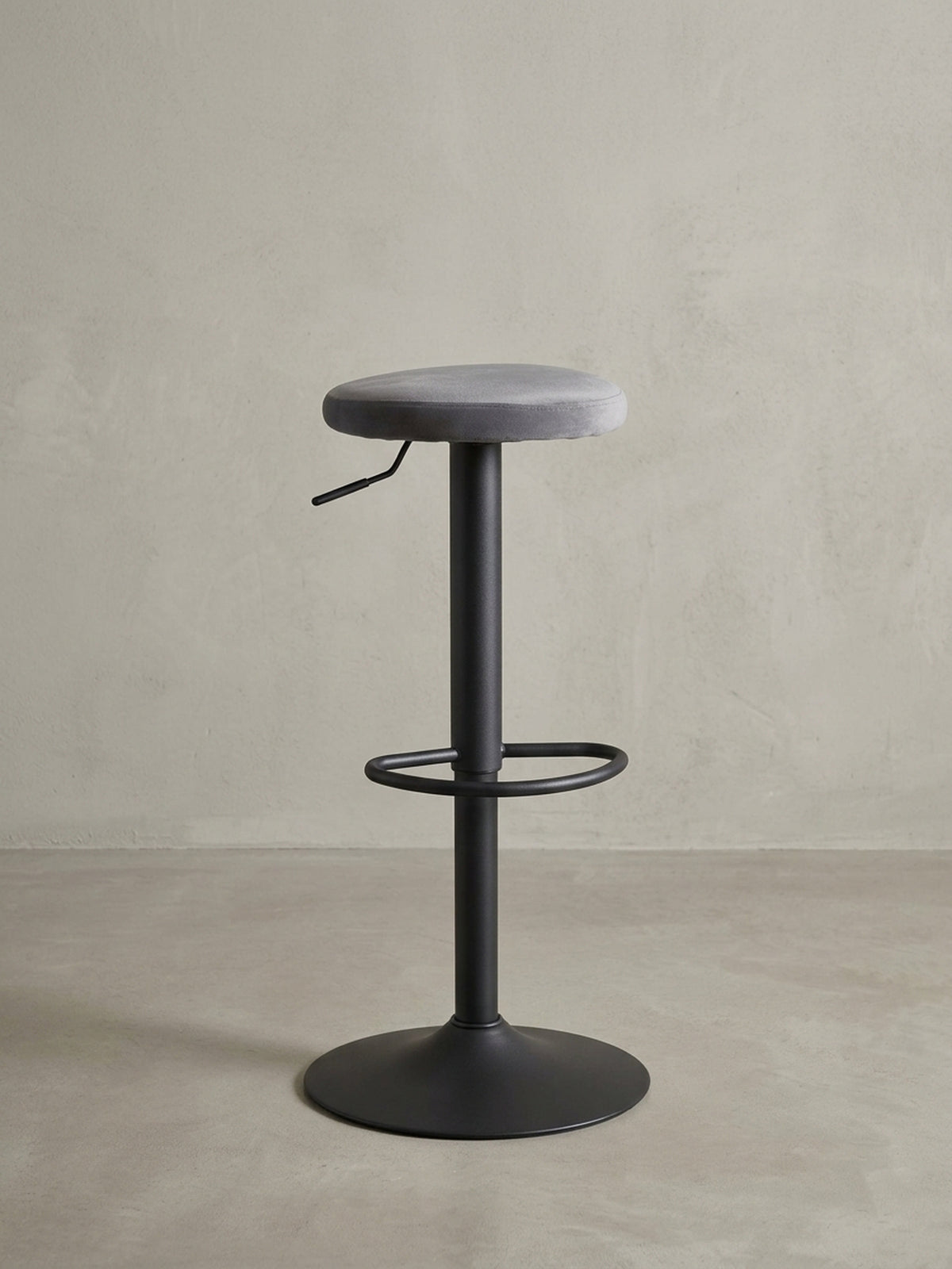 Seitenansicht des Bistrohockers, der die Proportionen des 35 cm breiten Sitzes zum 40 cm breiten Standfuß und die schlanke Mittelsäule zeigt.