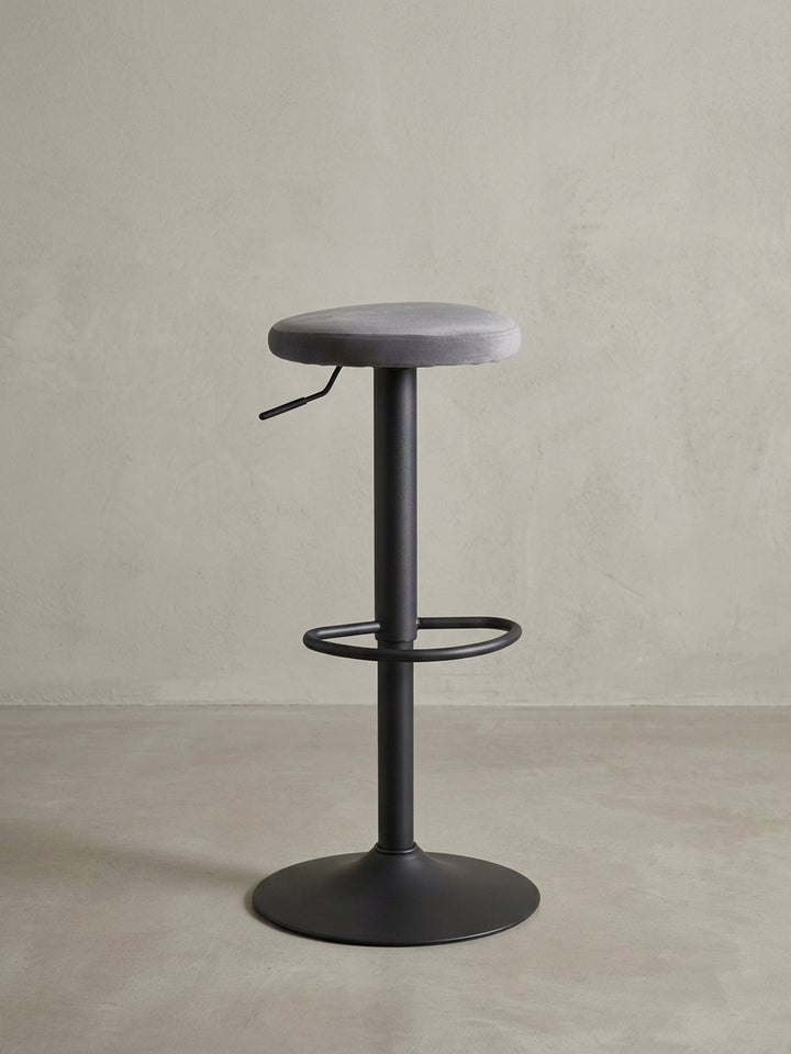 Seitenansicht des Bistrohockers, der die Proportionen des 35 cm breiten Sitzes zum 40 cm breiten Standfuß und die schlanke Mittelsäule zeigt._