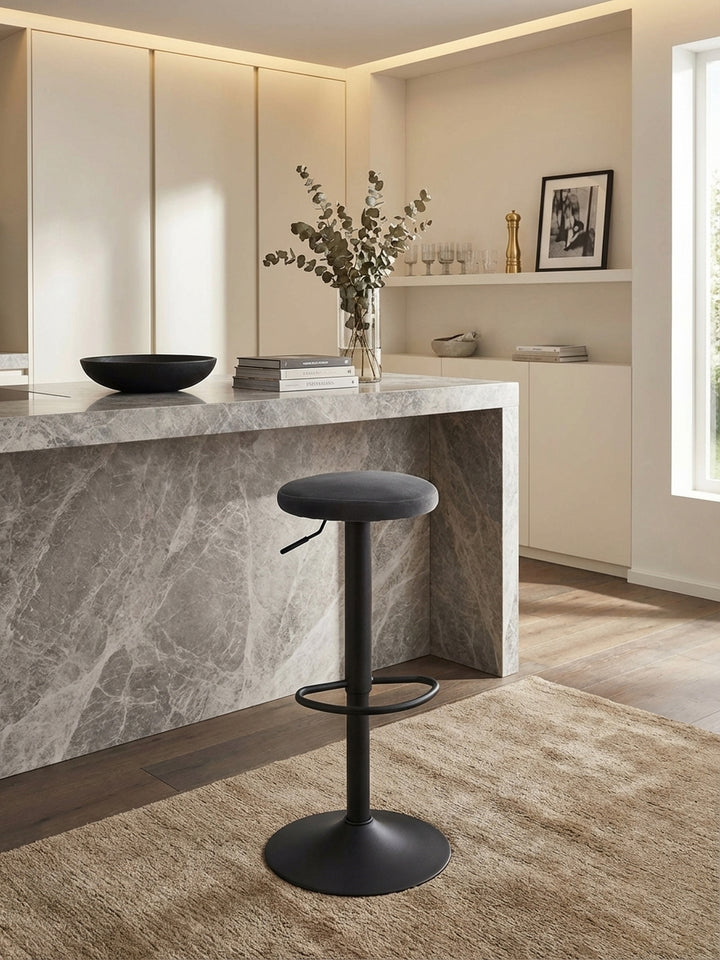 Draufsicht auf den drehbaren Tresenhocker mit Samtbezug, der in einem minimalistischen Interieur mit Designerküche und Holzboden steht._