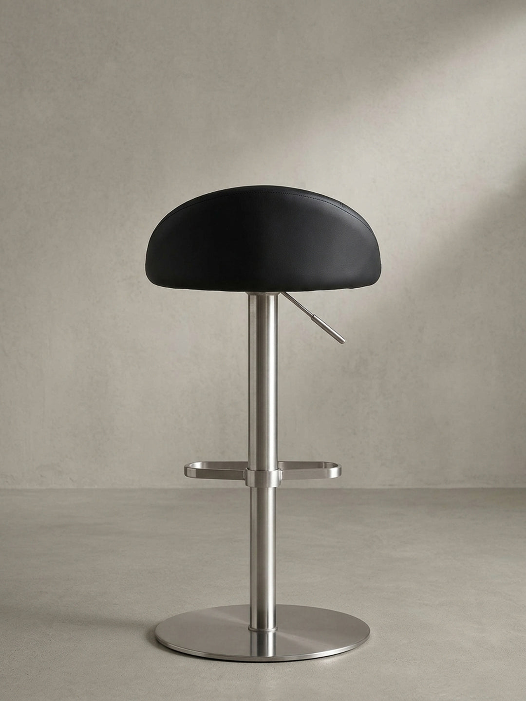 Ansicht des 360 Grad drehbaren Thekenhockers in Schwarz, der maximale Flexibilität und architektonisches Design am heimischen Bartisch vereint._