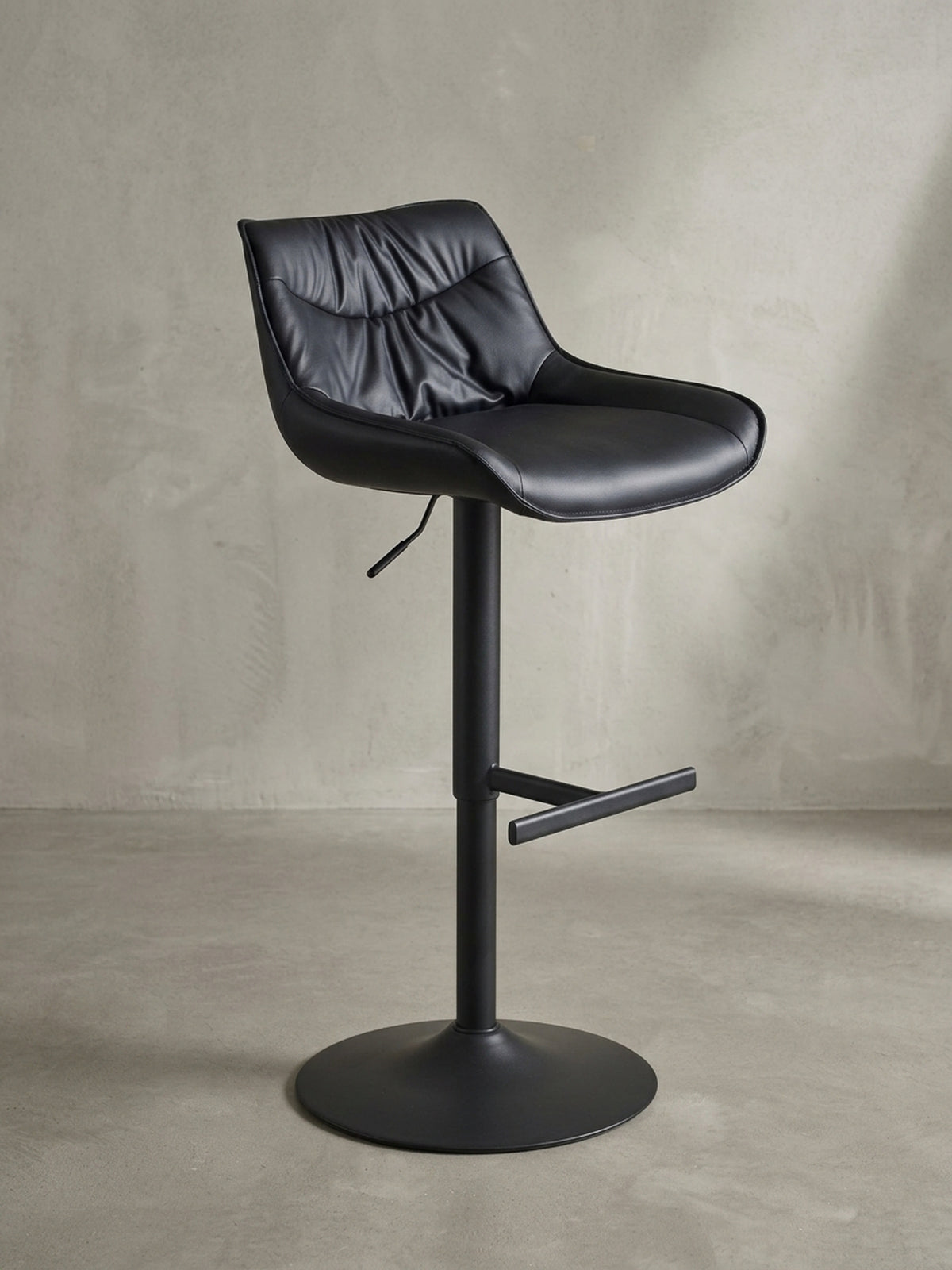 Eleganter Design-Barstuhl in Schwarz, in der 3/4-Ansicht, die die geschwungene Form der Sitzschale und die schlanke Säule zeigt.