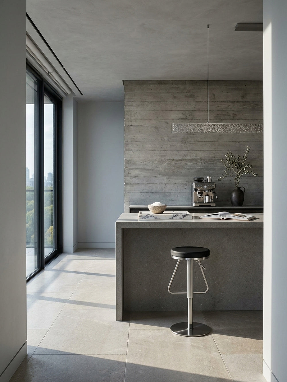 Moderner Barhocker in Schwarz mit Edelstahlgestell an einer freistehenden Kücheninsel aus dunklem Kalkstein im puristischen Architektenhaus._