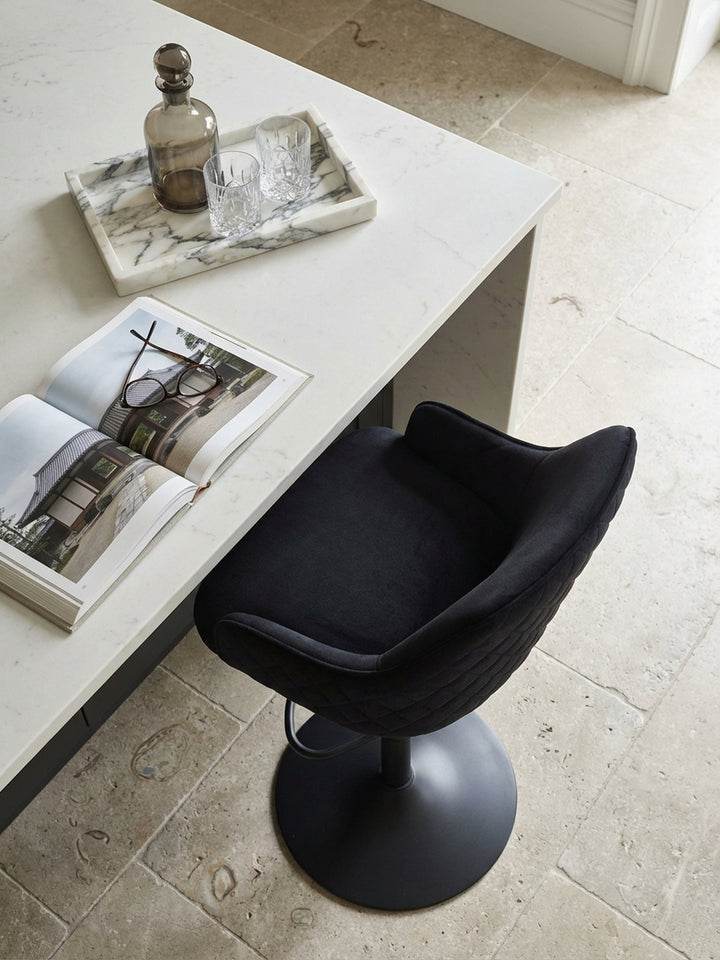 Zwei schwarze Samt-Barhocker von oben gesehen an einer modernen Kücheninsel, die das symmetrische Design und die harmonische Raumaufteilung im Art-déco-Stil zeigen._