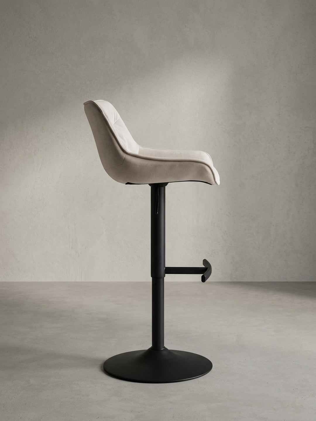 Seitenprofil des schlanken Barhockers aus Samt, das die ergonomische Form der Sitzfläche und die Verstellbarkeit der Sitzhöhe verdeutlicht._