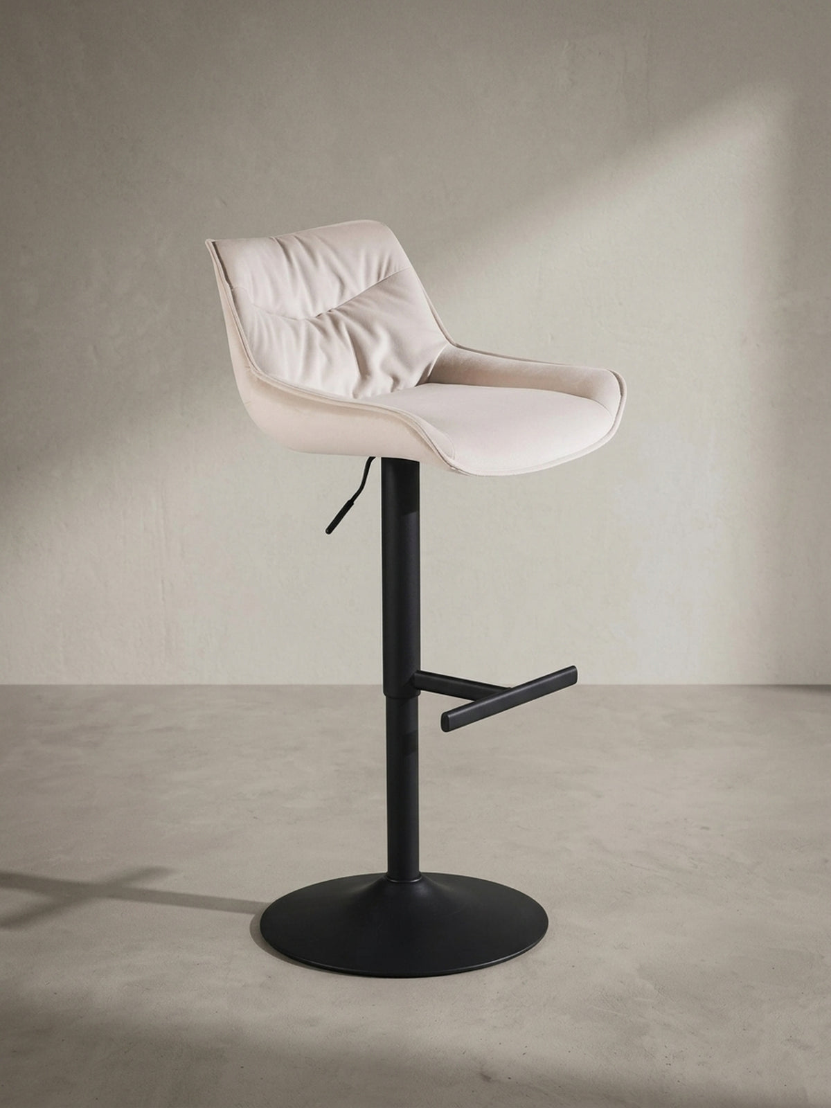 Gepolsterter Küchenhocker aus Samt in Beige aus einer alternativen Perspektive, die das Zusammenspiel von Komfort und modernem Design betont.