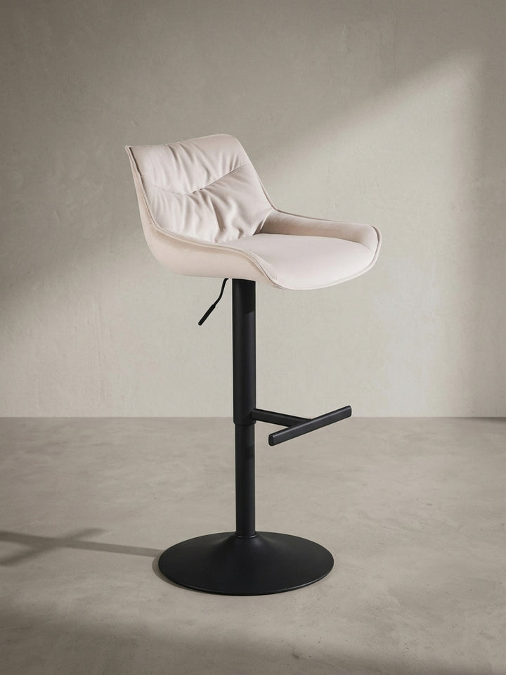 Gepolsterter Küchenhocker aus Samt in Beige aus einer alternativen Perspektive, die das Zusammenspiel von Komfort und modernem Design betont._