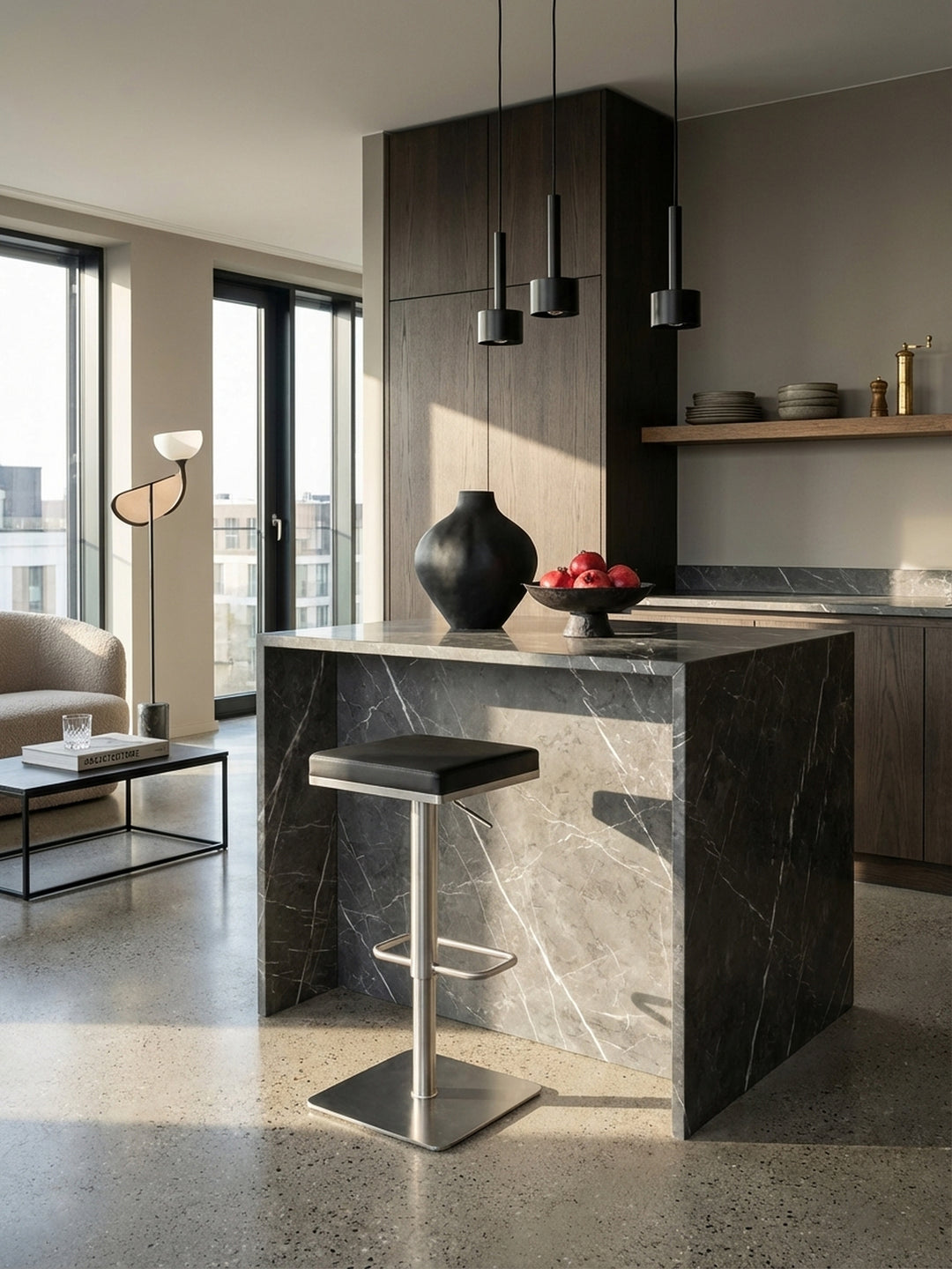 Moderner Barhocker mit schwarzem Kunstledersitz und Edelstahlgestell in einer minimalistischen Küche mit Marmortheke und Holzboden._