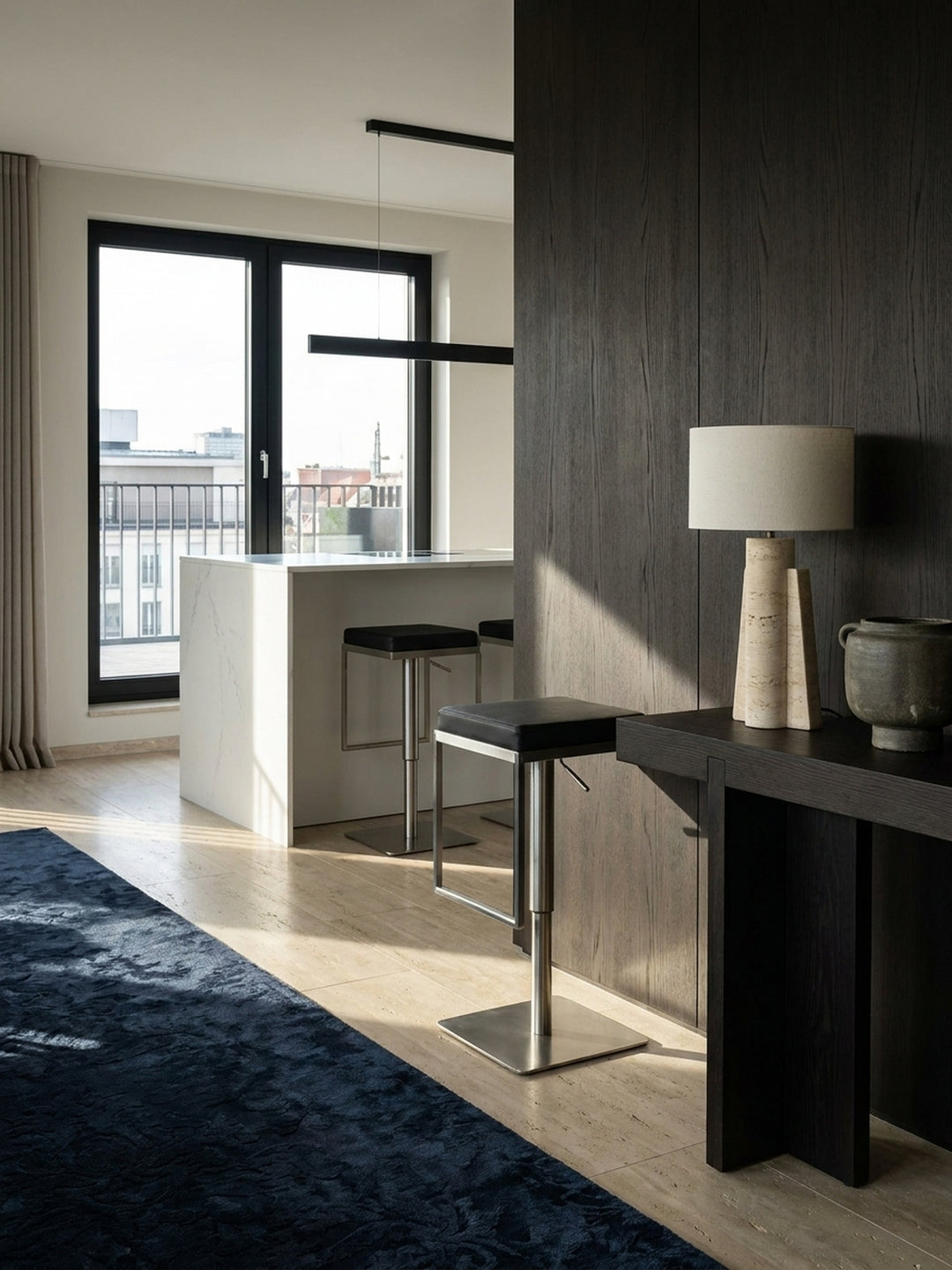 Zwei höhenverstellbare Barhocker in Schwarz stehen elegant nebeneinander an einem hohen Küchentresen, bereit für Gäste._