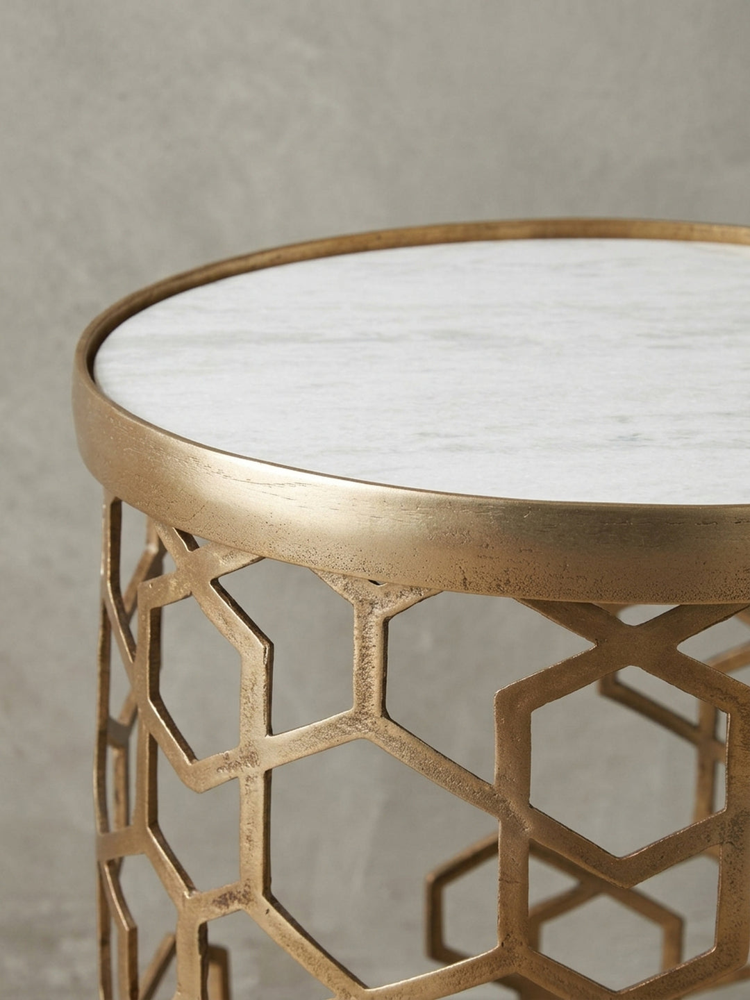 Nahaufnahme des goldenen Rahmens des Anstelltisches, die die gebürstete Oberfläche des Metalls und die präzisen Kanten des Sechseckmusters enthüllt._