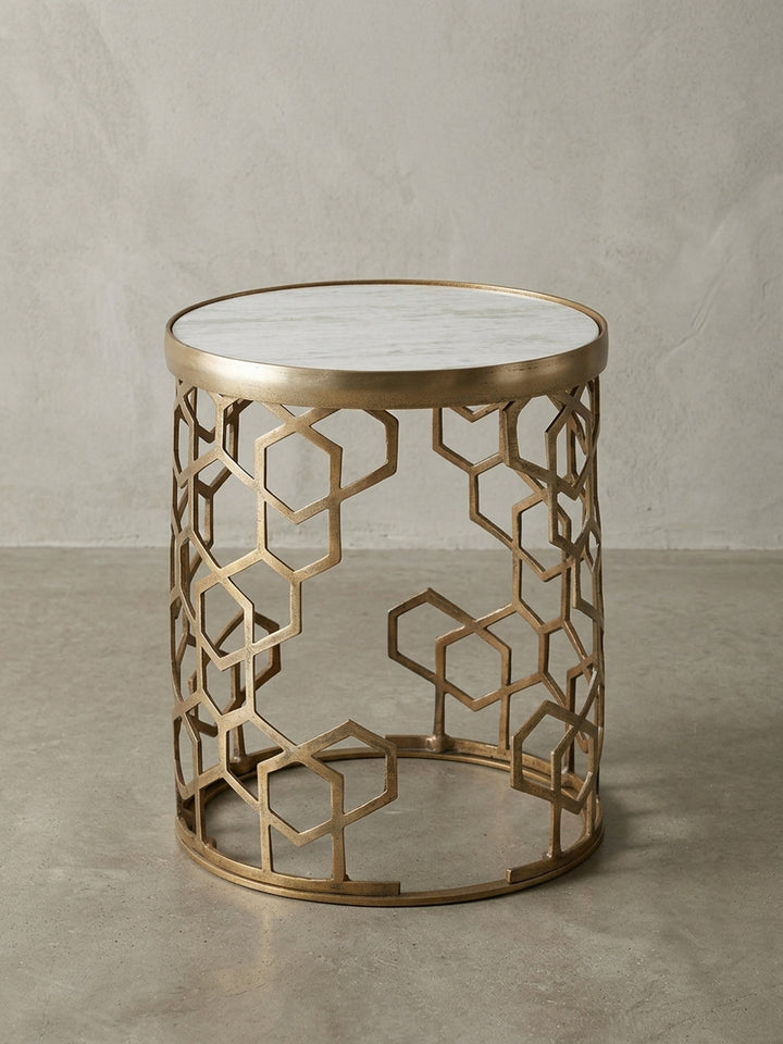 Eleganter runder Beistelltisch mit weißer Marmorplatte und goldenem Metallgestell im geometrischen Design, freigestellt auf weißem Hintergrund, Frontansicht._