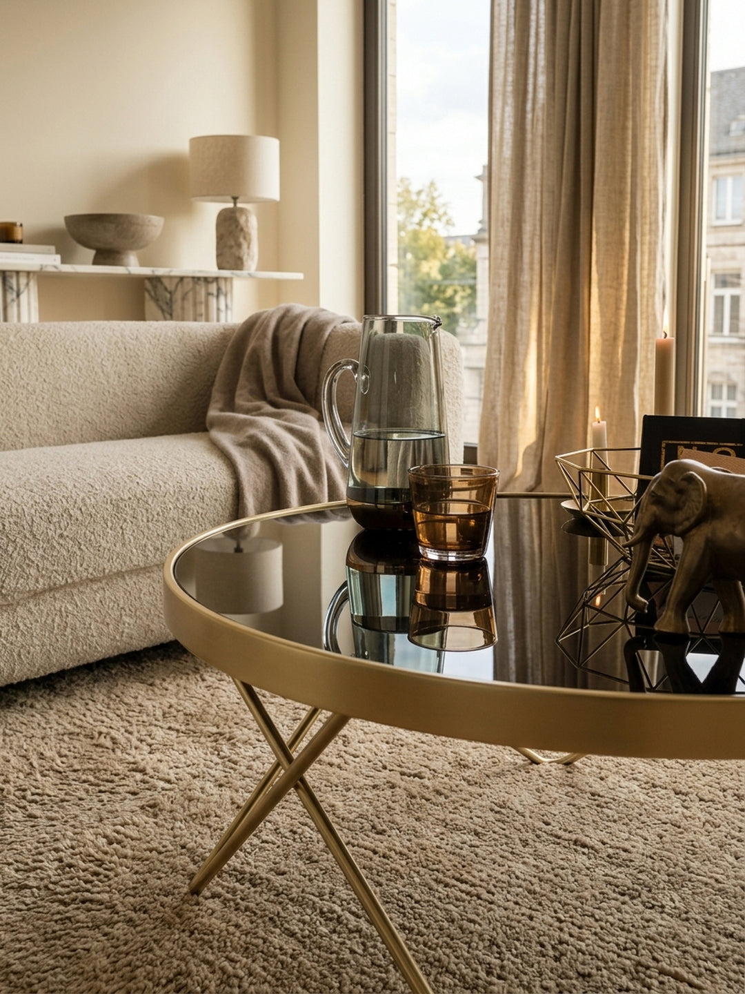 Nahaufnahme der edlen Tischoberfläche: Glänzendes schwarzes Sicherheitsglas trifft auf den matt gold lackierten Stahlrahmen. Hochwertige Materialien des Wohnzimmertisches im Detail._