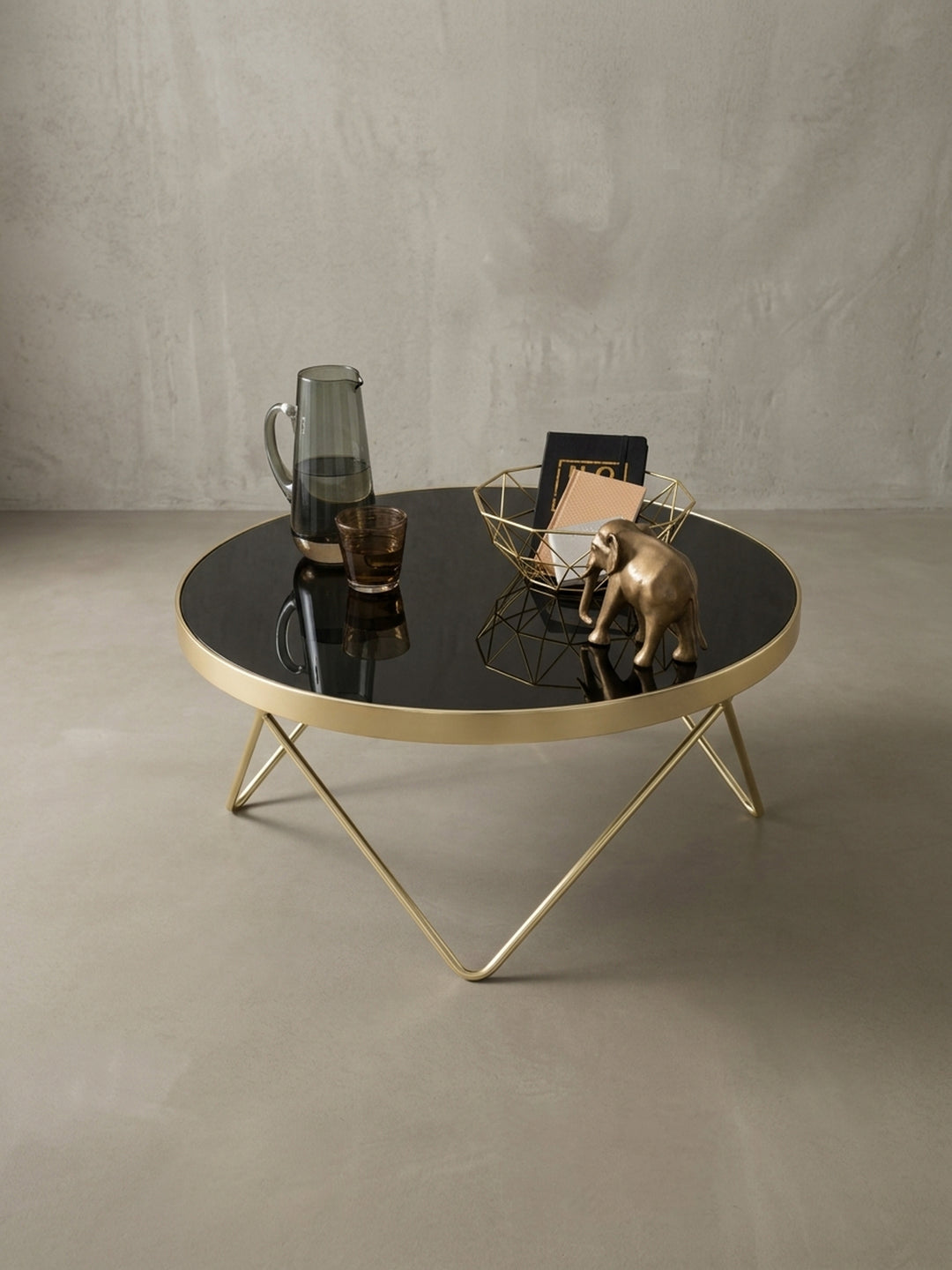 Der schwarz-goldene Wohnzimmertisch aus einem weiteren Winkel. Perfekte Symbiose aus mattem Stahl und glänzendem Glas, ideal als zentrales Element für moderne Wohnlandschaften._