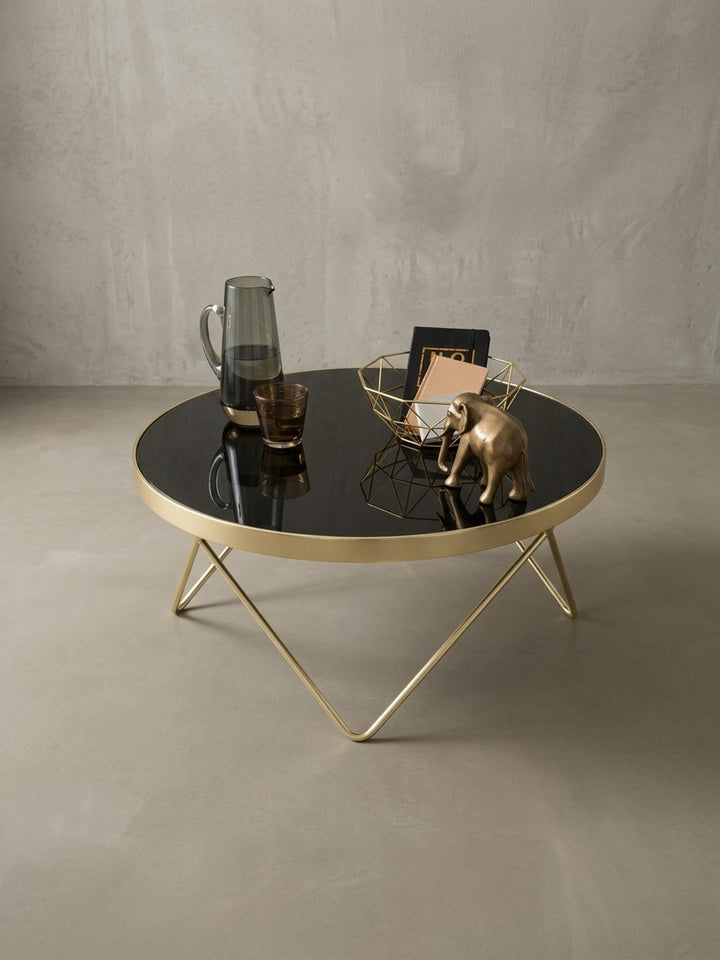 Der schwarz-goldene Wohnzimmertisch aus einem weiteren Winkel. Perfekte Symbiose aus mattem Stahl und glänzendem Glas, ideal als zentrales Element für moderne Wohnlandschaften._