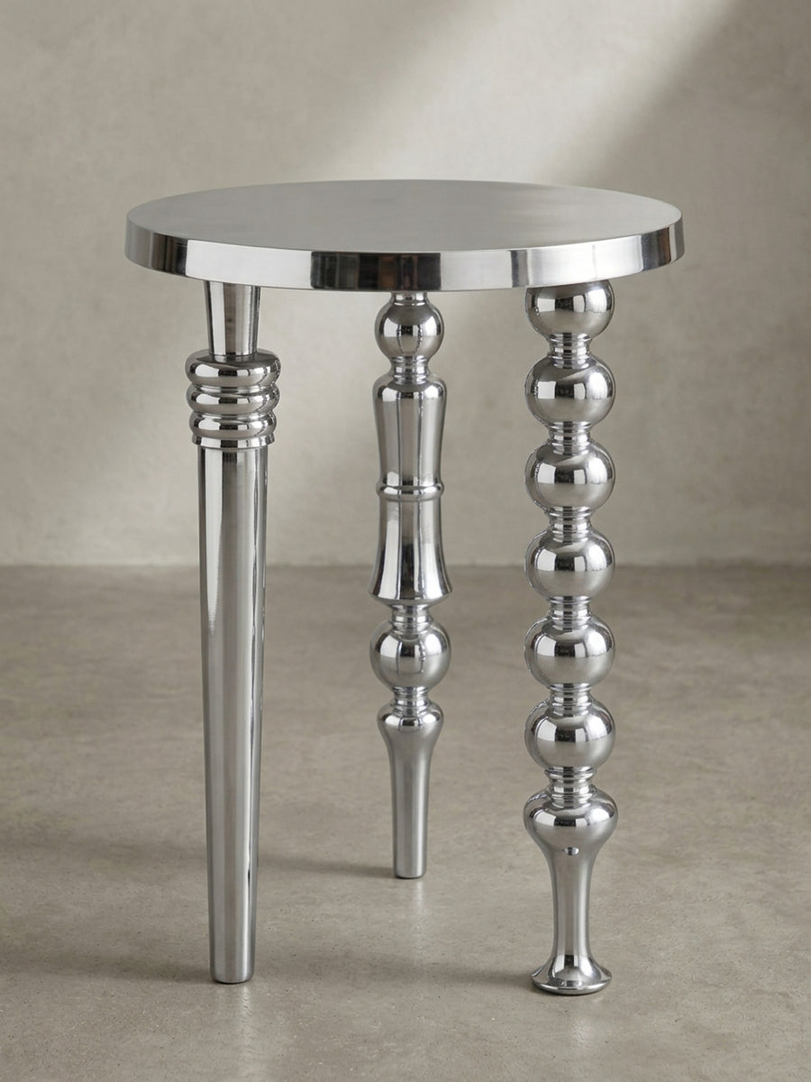 Makroaufnahme eines der drei Tischbeine, die die präzise Verarbeitung und die glänzende Oberfläche des handpolierten Aluminiums detailliert darstellt._