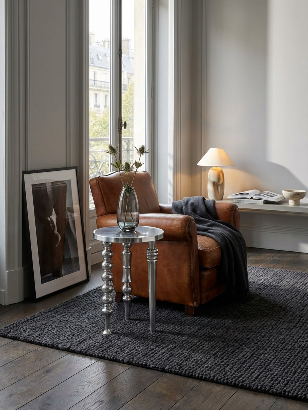 Der runde Alu-Abstelltisch harmoniert perfekt mit einem cremefarbenen Sofa und einem grob gewebten Teppich und schafft eine stilvolle Wohnatmosphäre._